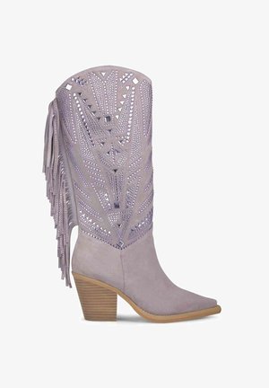 Botki w stylu zachodnim w jasnoszarym zamszu z ostro zakończonym noskiem, dekoracyjnymi wycięciami oraz frędzlami z boku. Obcas o wyglądzie drewna.