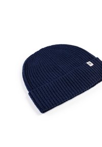 Navy knit beanie hat with ribbed texture and folded cuff. Features a small branded patch on the front. Soft, stretchy material.