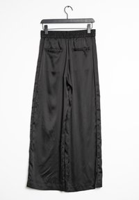 Svarta satin vidbyxor med elastisk midja, har två bakfickor och en slät yta, hängande på en svart galge.