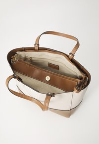 Grande borsa tote in una combinazione di ecopelle crema e beige, con hardware marrone, tasche interne e due manici per la spalla.
