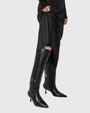 Stivali neri alti fino al ginocchio realizzati in pelle liscia, con punta affusolata e tacco a stiletto, caratterizzati da un design aderente e da una silhouette elegante.
