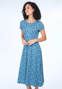 Blumenkleid mit blauem Grund und grünen sowie blauen Mustern, kurzen Ärmeln, rundem Ausschnitt und einem fließenden, knielangen Rock.