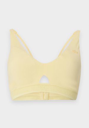 Mäkká žltá bezdrôtová podprsenka s nastaviteľnými tenkými ramienkami, výrezom v tvare kľúčovej dierky v strede a sieťovanou elastickou páskou so zapínaním na háčiky.