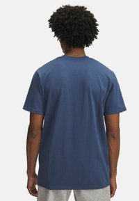 Blue cotton t-shirt featuring short sleeves, crew neck, and a relaxed fit. The back has a smooth texture with no visible patterns or accents.