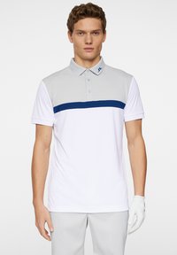 White polo shirt with gray shoulders and a blue horizontal stripe. Features a collar, short sleeves, and a logo on the collar.