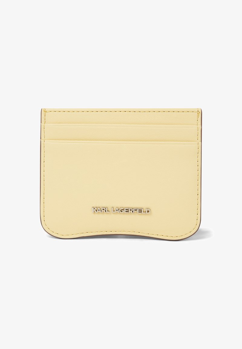 Porte-cartes en cuir jaune pâle avec trois emplacements pour cartes et logo métallique "KARL LAGERFELD" au centre avant.