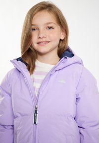 Giacca puffer lilla con cappuccio blu navy, caratterizzata da un logo di ombrello argentato, chiusura a zip e dettagli a costine. Indossata sopra una maglietta a righe.