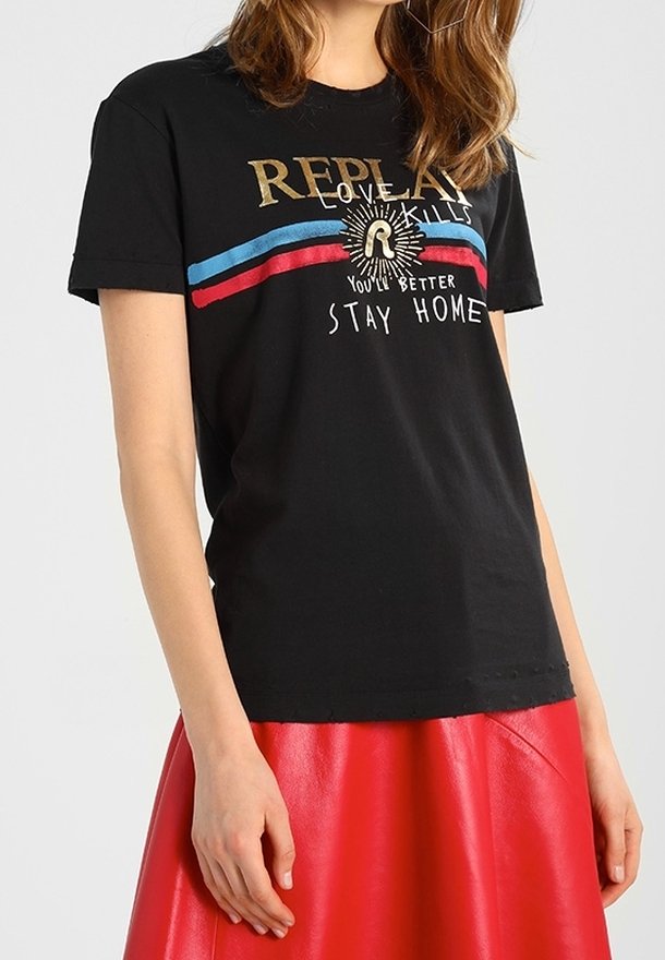 Woman wearing black short-sleeve T-shirt with blue and red stripes and text, paired with a red leather skirt.