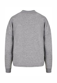 Grå sweatshirt med rund halsringning, sänkt axelsöm och ribbade muddar. Mjukt, texturerat tyg med en minimalistisk design.