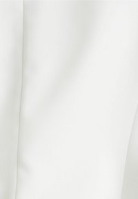 Biały materiał o gładkiej fakturze i delikatnym połysku. Charakteryzuje się czystymi, prostymi szwami, co nadaje minimalistyczny wygląd.