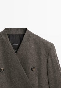 Cappotto grigio in lana doppiopetto con colletto a risvolto, caratterizzato da due bottoni neri e un tessuto texturizzato. Etichettato all'interno con "Massimo Dutti."