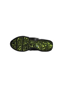 Talpa de pantof sport negru cu o suprafață texturată, modelată, care prezintă accente verzi și șanțuri adânci pentru aderență.