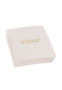 Scatola quadrata, di un rosa pallido con angoli arrotondati e una superficie liscia, con la parola "amor" in rilievo in lettere dorate sulla parte superiore.