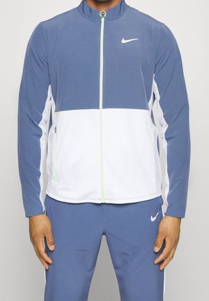 Chaqueta Nike en azul y blanco, con diseño de cierre frontal con cremallera, cuello alzado y acentos de malla texturizada. Tejido suave con detalle de logo.