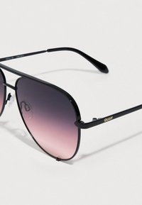 Czarne metalowe okulary przeciwsłoneczne z gradientowymi fioletowymi szkłami. Na zauszniku subtelne złote logo "QUAY". Cienka, elegancka konstrukcja oprawek.