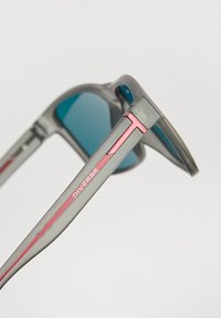 Okulary przeciwsłoneczne z szarym plastikowym ramkiem, turkusowymi soczewkami i różowymi akcentami na zausznikach, z eleganckim wzornictwem i logo po boku.
