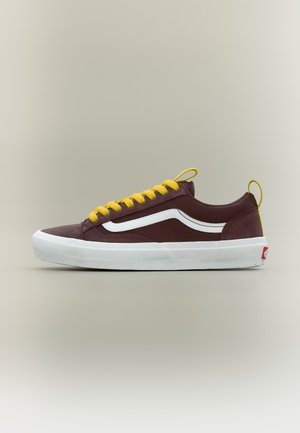 Baskets basses bordeaux avec bande latérale blanche, lacets jaunes, semelle blanche et languettes jaunes sur fond beige.
