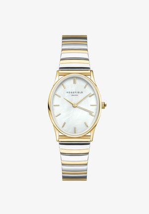 Reloj dorado con una esfera ovalada de nácar blanco, marcadores de hora dorados y una pulsera de metal bicolor que presenta rayas alternas de oro y plata.