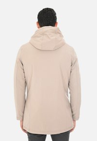 Giacca beige con cappuccio dalla finitura liscia e opaca. Presenta cuciture sagomate, una vestibilità comoda e un design di lunghezza media.