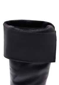 Botte en cuir noir hauteur genou avec un revers souple et texturé, présentant une finition lisse et des détails de couture précis.