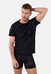 Svart idrottströja med blå detaljer, korta ärmar och rund halsringning; kombinerad med svarta nätboxershorts. Slät textur.
