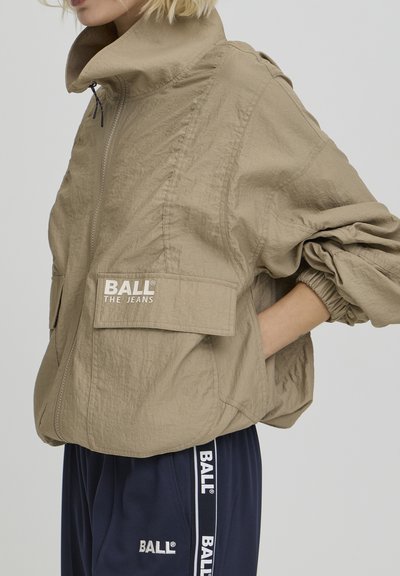 Veste en nylon kaki avec poignets élastiques, col montant et poches avant. Présente le logo « BALL THE JEANS » sur la poitrine.