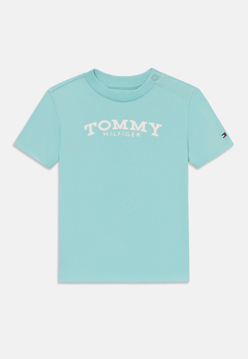 Svetlo modré tričko s krátkym rukávom vyrobené z bavlny, s potlačou loga "TOMMY HILFIGER" v bielej farbe na prednej strane a malým logom na rukáve.
