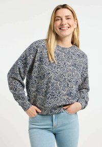 Felpa navy con motivo floreale crema, scollatura rotonda e maniche lunghe, abbinata a jeans blu chiaro. Tessuto morbido.