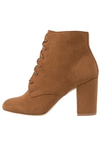 Bruna faux-suede ankelsko med spetsig tå, snörning framtill och tjock klack, med en slät textur och minimal detaljer.