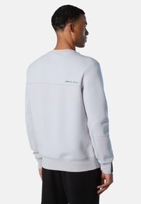 Felpa grigio chiaro con polsini e orlo a costine, presenta un design a yoke parziale e il logo "NORTH SAILS" stampato in nero sulla parte superiore della schiena.