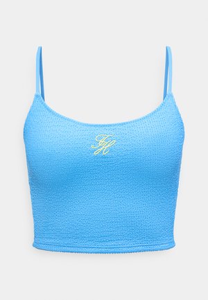 Modri teksturiran kratki top z tankimi naramnicami in majhnimi rumenimi vezenimi začetnicami na sredini prsnega koša.