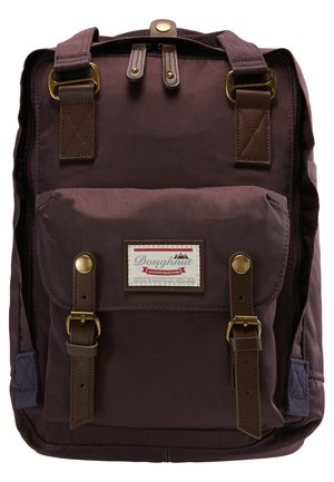 Lilla nylon ryggsekk med brune lærdetaljer, rektangulær form, frontlomme med klaff og metallbeslag. Har en merkevarelogo på forsiden.