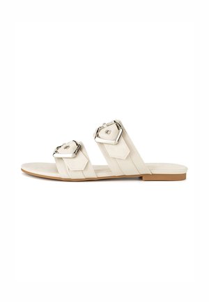 Białe płaskie sandały z dwoma szerokimi paskami z kwadratowymi metalowymi klamrami. Gładka tekstura, minimalistyczny design i płaska gumowa podeszwa.