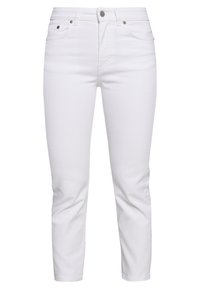 Vaqueros de mezclilla blanca con un diseño ajustado, cintura media, cinco bolsillos y costuras mínimas, con una textura suave y cierre de botón.