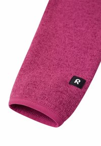 Fleece-Ärmel in hellem Lila mit strukturierter Oberfläche. Verfügt über ein glattes Innenfutter und ein schwarzes Etikett mit einem weißen Logo nahe dem Bündchen.