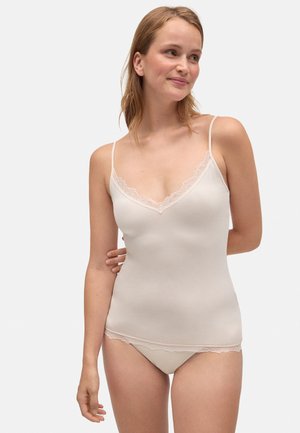 Camiseta sin mangas de color beige claro con encaje en el escote y el dobladillo, con tirantes finos ajustables y una textura de tela suave y elástica.