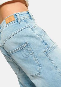 Lichtblauwe denim jeans met een hoge taille, voorzien van een leren label op de achterkant en twee achterzakken met stikdetails.