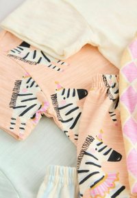 Sæt af bomuldsbeklædning med lyse farver, herunder fersken med zebra mønstre, pastell blå og et lyserødt argyle design. Blød tekstur.