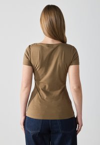 Short-sleeve brown t-shirt with a round neckline, fitted cut, and smooth texture. Details include stitching along the hem and sleeves.