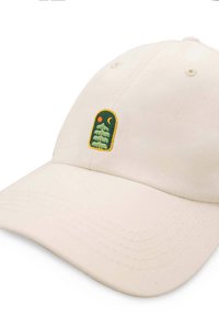 Miękka beżowa czapka bejsbolowa z zakrzywionym daszkiem. Posiada zieloną haftowaną grafikę drzewa wewnątrz żółtego łuku, uzupełnioną pomarańczowymi detalami.
