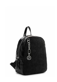 Sac à dos en cuir noir avec fermeture éclair à l’avant, chaîne argentée et breloque ronde avec logo SF, et poignée supérieure sur fond blanc.