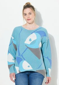Ljusblå tröja med abstrakta fiskmönster i mörkare blått och grått. Ribbad nederkant och ärmslut, avslappnad passform, texturerat stickat material.
