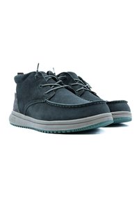 Botas de tobillo de ante gris con punta redonda, suela gris contrastante y cierre de cordones. Presentan un detalle de costura y un acento texturizado en la parte trasera.