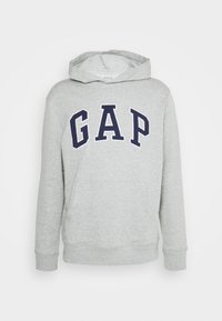 Felpa grigia chiara con cappuccio, con testo "GAP" blu navy sul petto e tasca a marsupio frontale, mostrata su sfondo bianco.