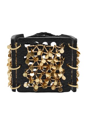 Szeroka czarna skórzana bransoletka mankietowa z przeplatanymi złotymi ogniwami łańcucha i małymi okrągłymi złotymi zawieszkami przymocowanymi do przedniej części.