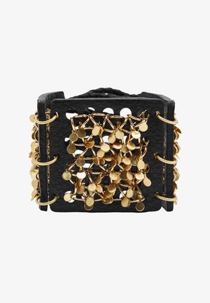 Szeroka czarna skórzana bransoletka mankietowa z przeplatanymi złotymi ogniwami łańcucha i małymi okrągłymi złotymi zawieszkami przymocowanymi do przedniej części.