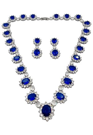Collana di gemme blu con accenti in argento e impostazioni floreali, caratterizzata da un insieme di pietre ovali e rotonde, completata da orecchini coordinati.