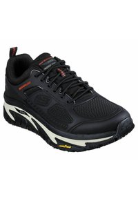Schwarzer Sportschuh mit strukturierter Oberfläche, ausgestattet mit wasserabweisendem Material, gepolstertem Schaft und weißen Akzenten an der Sohle. Markenlogo sichtbar.