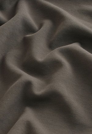 Karkea ruskea kangas, jossa on sileitä, aaltoilevia laskoksia; siinä on hienovarainen raidoitettu kuvio ja pehmeä, mattapintainen viimeistely.