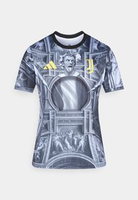 Αθλητική φανέλα με κοντά μανίκια σε σκούρο σχέδιο γραφικών που περιλαμβάνει κλασικά καλλιτεχνικά μοτίβα. Τα υλικά φαίνονται λεία με εφαρμοστή σιλουέτα.